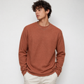 Man wearing a brown ribbed sweater against a white background