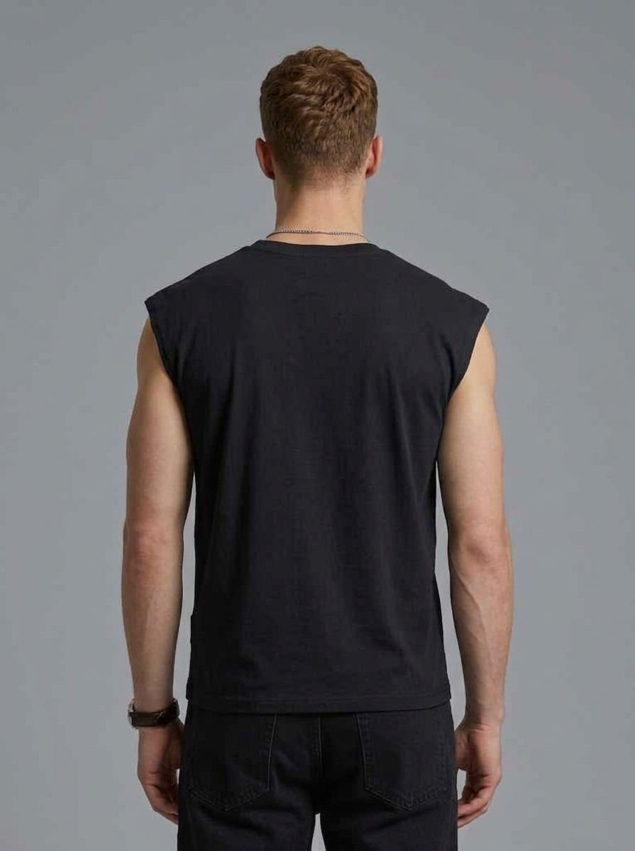Man wearing a black sleeveless shirt against a gray background